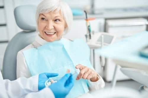 A senior woman visiting the dentist prepared with her dentist checklist