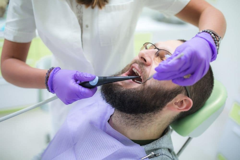 Man laying in the dentist seat getting cavities removed