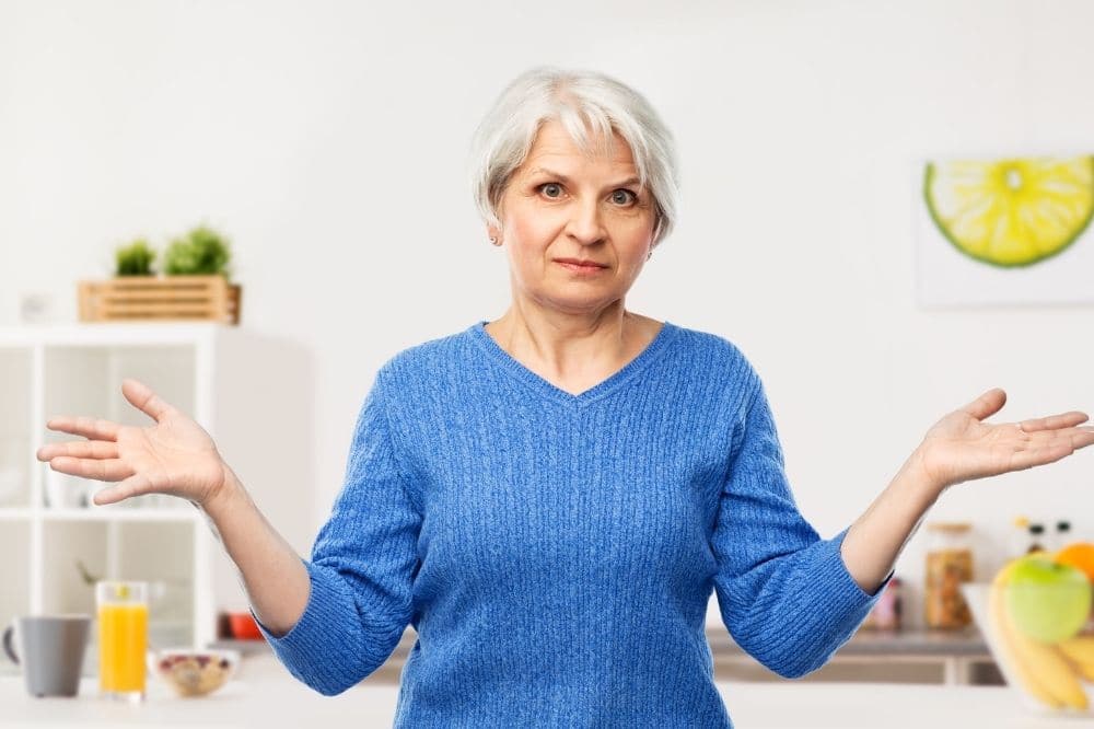 Mature woman trying to decide Between a Root Canal or Dental Implants for Root Infections – Looking at her Options